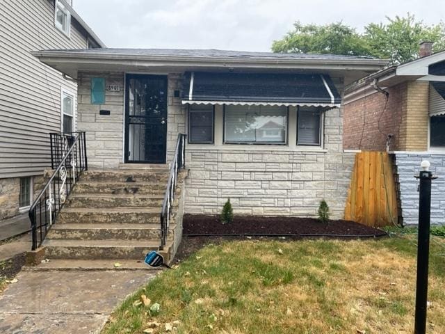 view of front of property featuring stone siding and a front yard