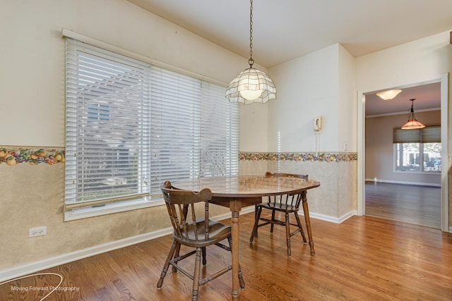 dining space featuring hardwood / wood-style flooring and ornamental molding