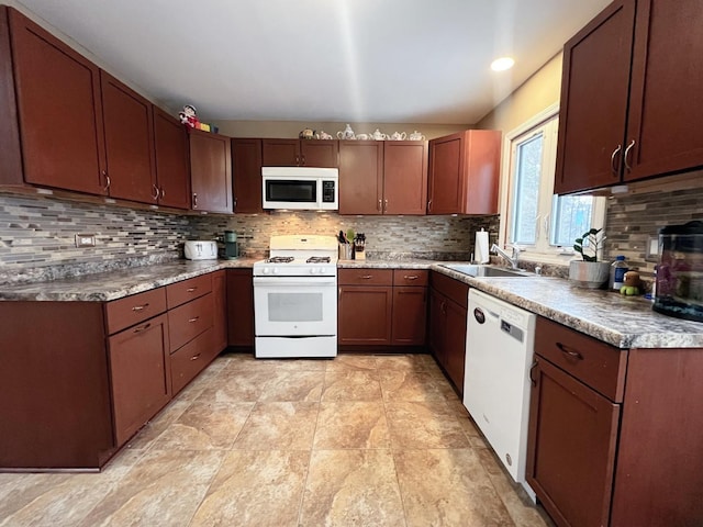 kitchen featuring backsplash, sink, and white appliances