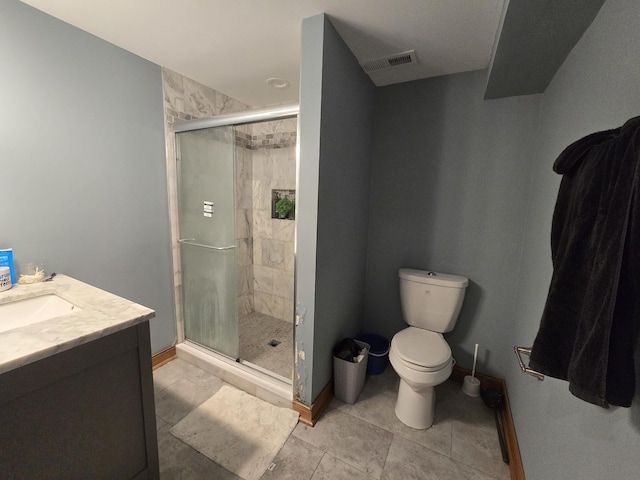 bathroom featuring tile patterned flooring, vanity, an enclosed shower, and toilet