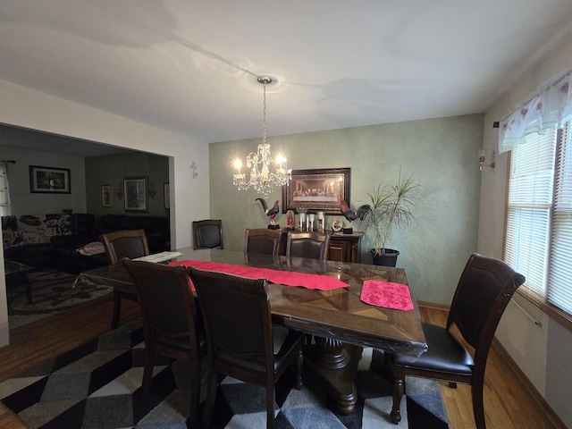 dining space featuring hardwood / wood-style floors, plenty of natural light, and a chandelier