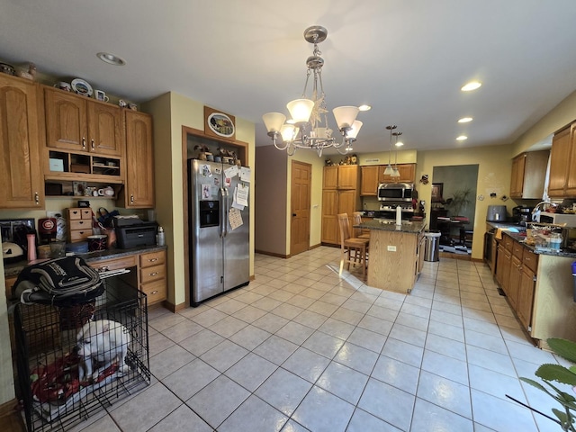 kitchen with an inviting chandelier, dark stone countertops, decorative light fixtures, a kitchen island, and stainless steel appliances