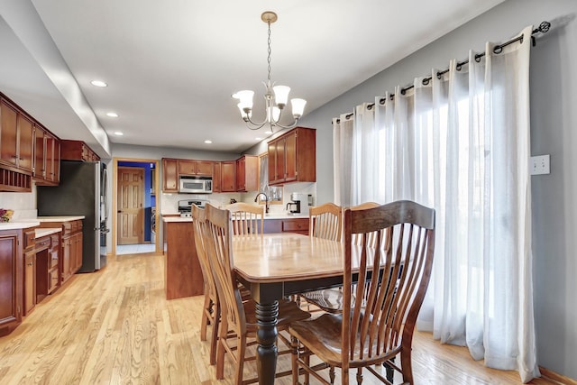 dining room featuring an inviting chandelier and light hardwood / wood-style flooring