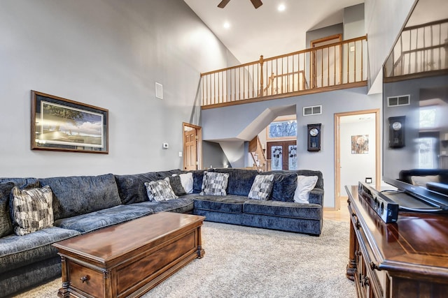 carpeted living room featuring a towering ceiling, french doors, and ceiling fan