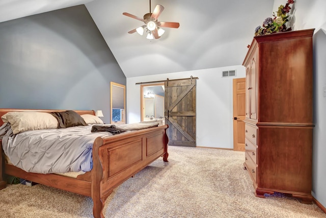 carpeted bedroom with ceiling fan, vaulted ceiling, and a barn door