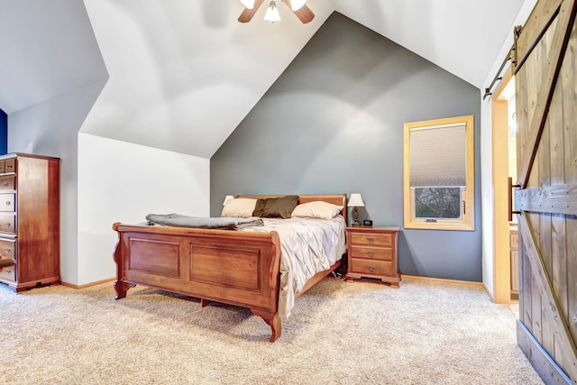 carpeted bedroom with ceiling fan, vaulted ceiling, and a barn door