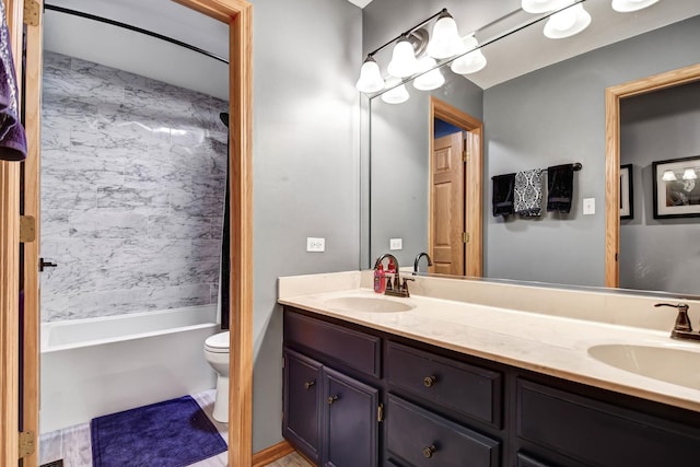 full bathroom featuring tiled shower / bath, vanity, and toilet