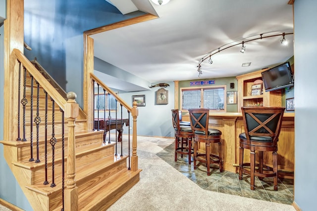 bar with carpet floors and rail lighting