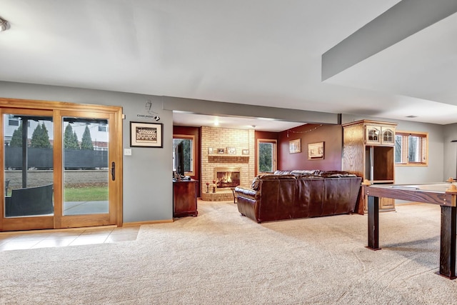 living room featuring a brick fireplace and light carpet