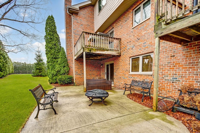 view of patio featuring an outdoor fire pit and a balcony