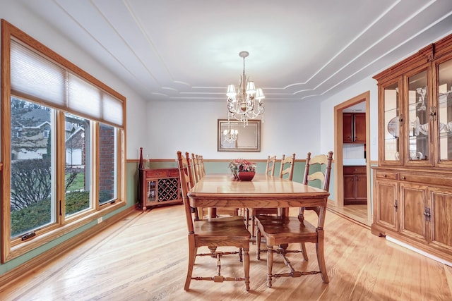 dining area with a notable chandelier and light hardwood / wood-style floors