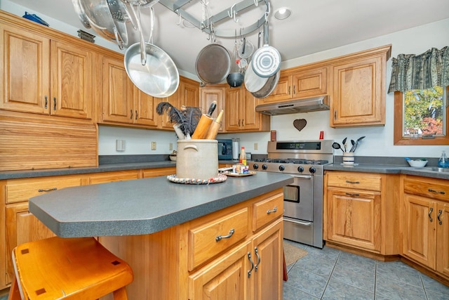 kitchen featuring a kitchen breakfast bar, a center island, light tile patterned floors, and stainless steel appliances