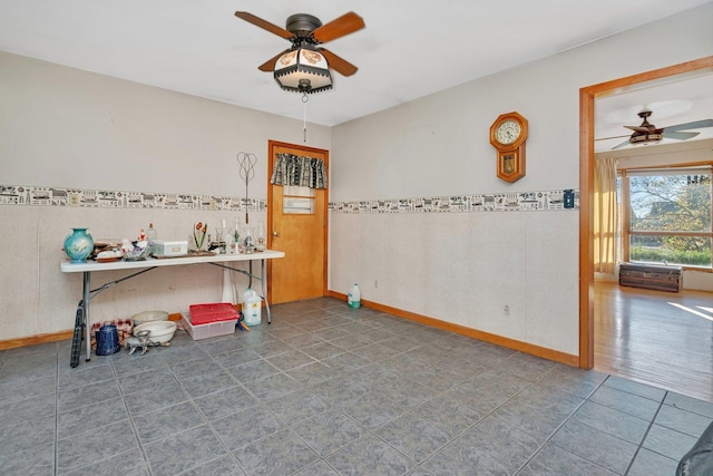 interior space featuring ceiling fan and tile walls