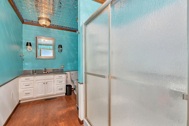 bathroom featuring walk in shower, hardwood / wood-style floors, vanity, and ornamental molding