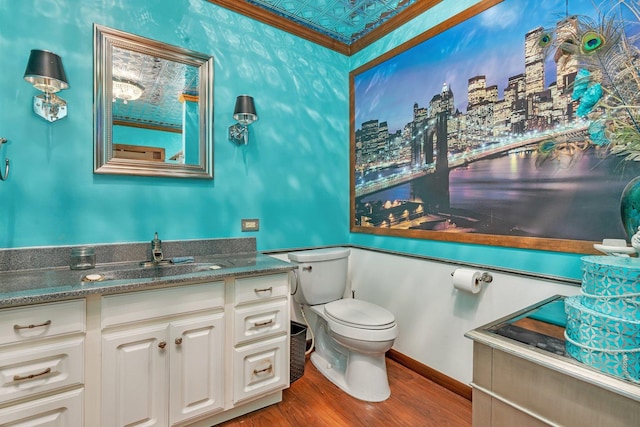 bathroom with vanity, hardwood / wood-style flooring, toilet, and ornamental molding