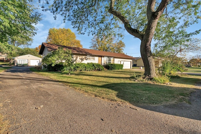 single story home featuring a garage and a front yard