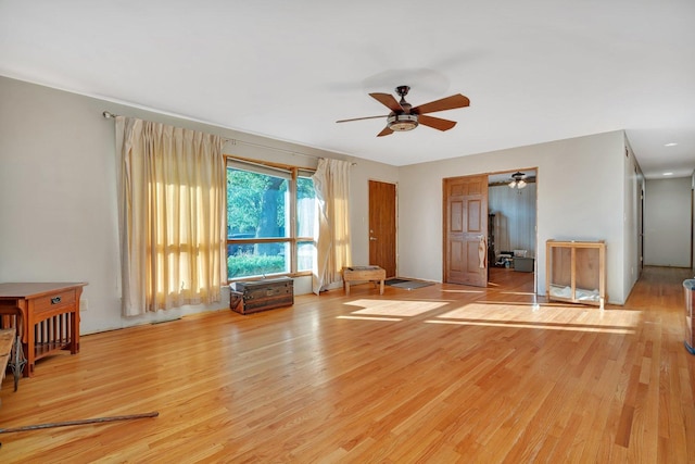 unfurnished living room featuring ceiling fan and light wood-type flooring