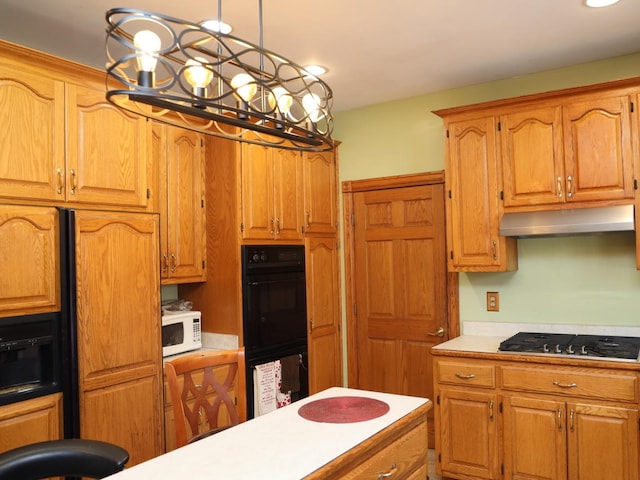 kitchen with gas cooktop, black double oven, and hanging light fixtures