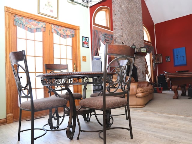 dining space featuring light hardwood / wood-style floors and high vaulted ceiling