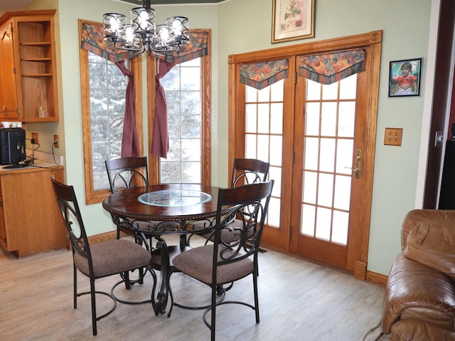 dining area with light hardwood / wood-style flooring and a notable chandelier