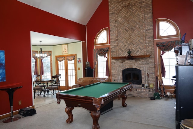 game room with pool table, an inviting chandelier, high vaulted ceiling, and a brick fireplace