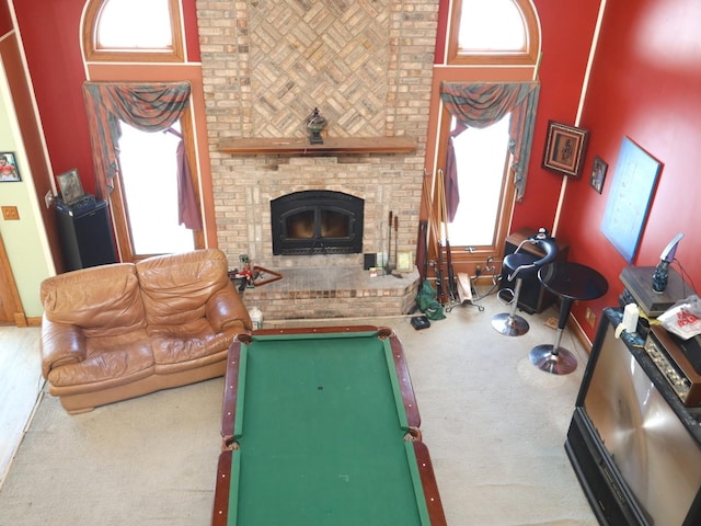 living room with a brick fireplace, plenty of natural light, carpet floors, and billiards