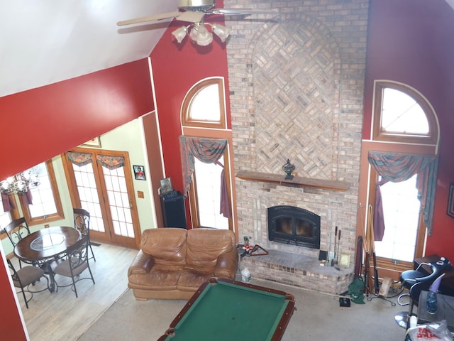 living room with french doors, a brick fireplace, ceiling fan, high vaulted ceiling, and pool table