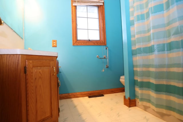 bathroom featuring vanity, toilet, and walk in shower