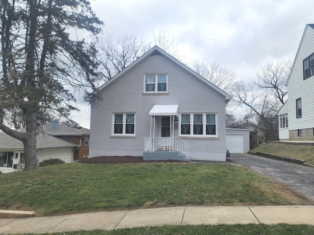 view of front of property featuring an outdoor structure, a front yard, and a garage