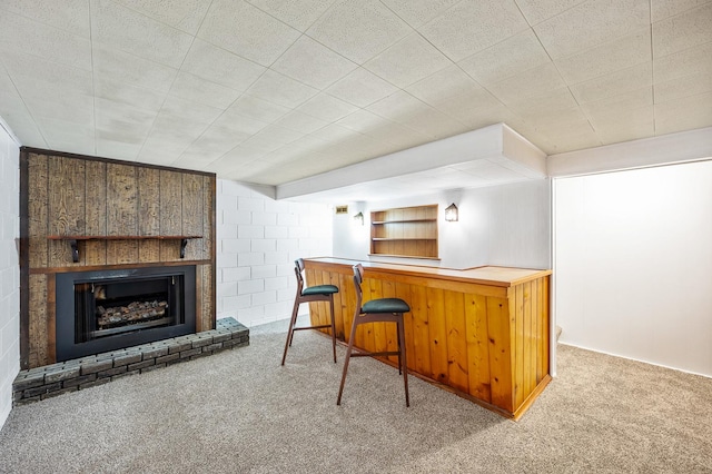 bar with carpet floors and a brick fireplace