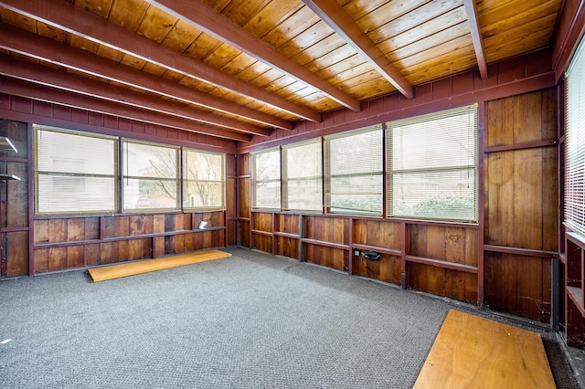 sunroom / solarium featuring beamed ceiling, plenty of natural light, and wooden ceiling