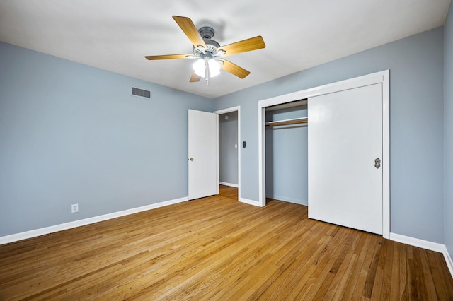 unfurnished bedroom featuring a closet, light hardwood / wood-style floors, and ceiling fan