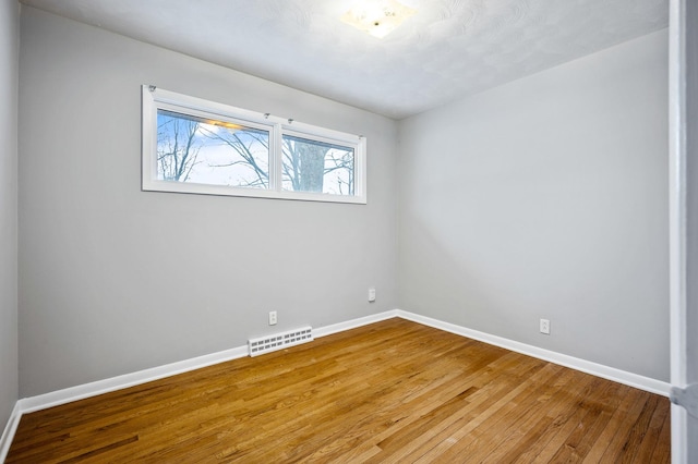 empty room with hardwood / wood-style flooring