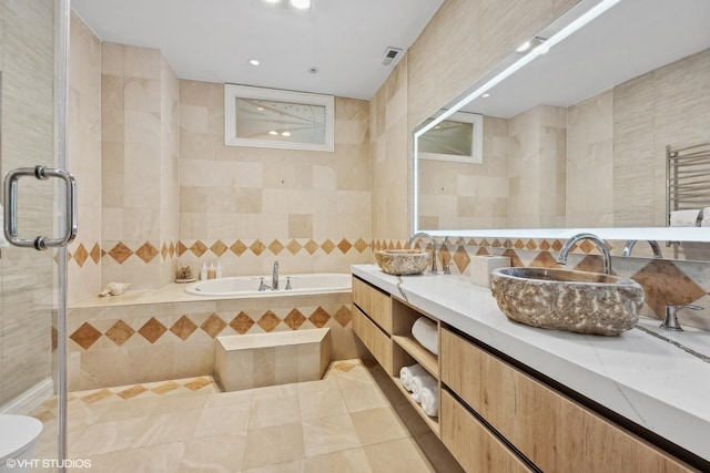 bathroom featuring tile walls, tile patterned flooring, radiator heating unit, vanity, and shower with separate bathtub