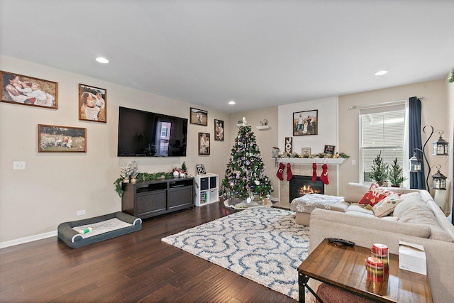 living room featuring dark wood-type flooring and a tiled fireplace