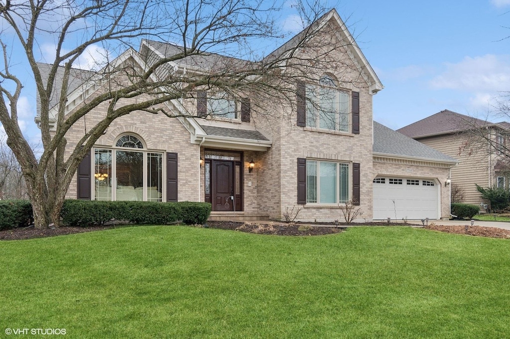 view of front of property featuring a front yard and a garage