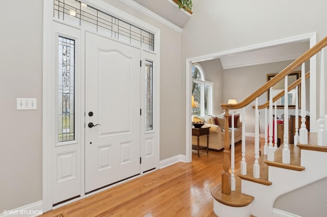 entryway with hardwood / wood-style floors and ornamental molding