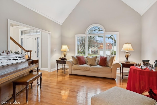 living room featuring light wood-type flooring, high vaulted ceiling, and ornamental molding