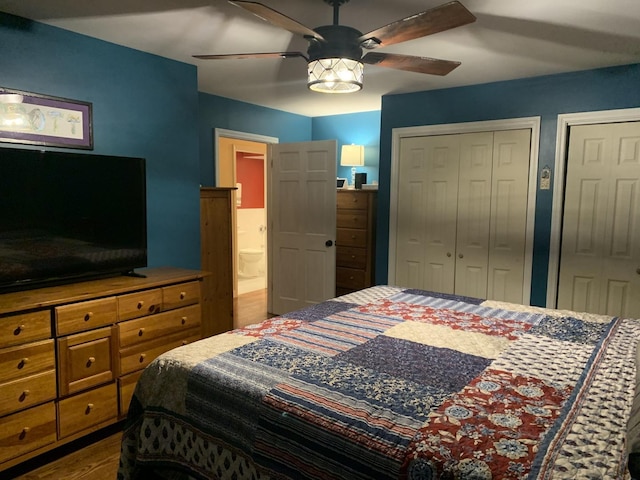 bedroom featuring ceiling fan, ensuite bathroom, and two closets