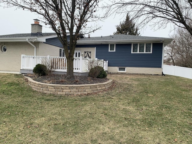 back of house featuring a lawn and a deck