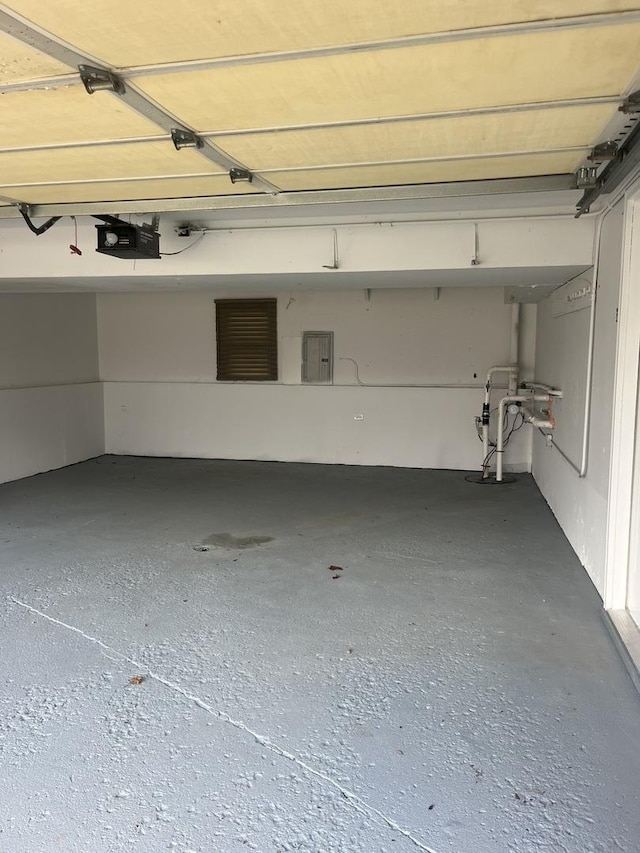 garage featuring electric panel and a garage door opener