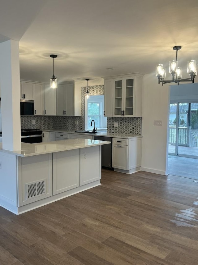 kitchen featuring white cabinetry, dark hardwood / wood-style floors, appliances with stainless steel finishes, and plenty of natural light