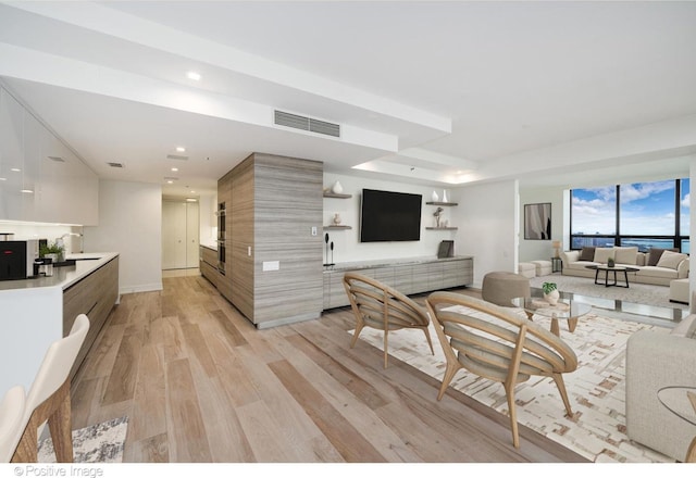 living room featuring light wood-style flooring, visible vents, and recessed lighting