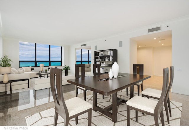 dining space featuring baseboards, visible vents, and crown molding