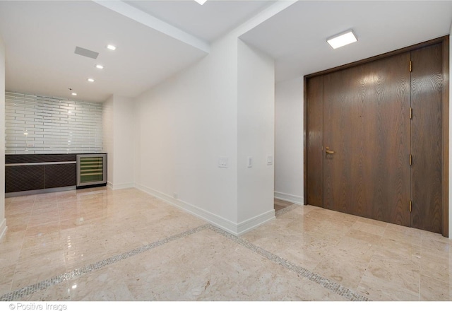 interior space with beverage cooler, recessed lighting, visible vents, and baseboards