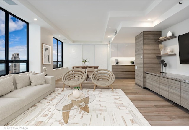 living room featuring expansive windows, recessed lighting, visible vents, and light wood-style floors