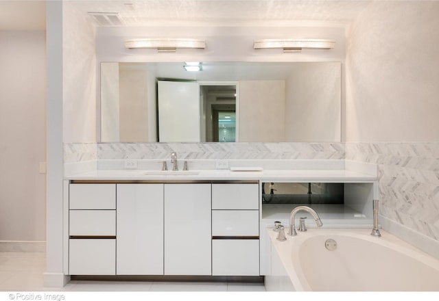 full bath featuring visible vents, a garden tub, and vanity