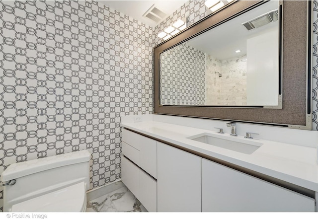 bathroom featuring toilet, marble finish floor, visible vents, and vanity