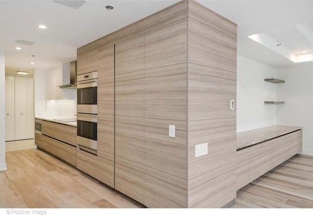 kitchen featuring light countertops, stainless steel double oven, light wood-style flooring, and recessed lighting