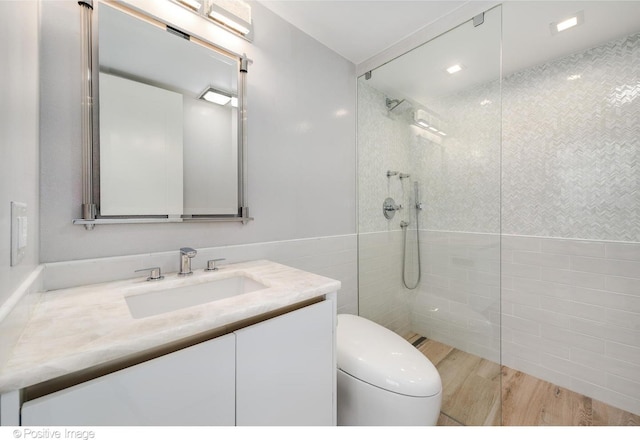 full bathroom featuring wood finished floors, tile walls, toilet, and a walk in shower